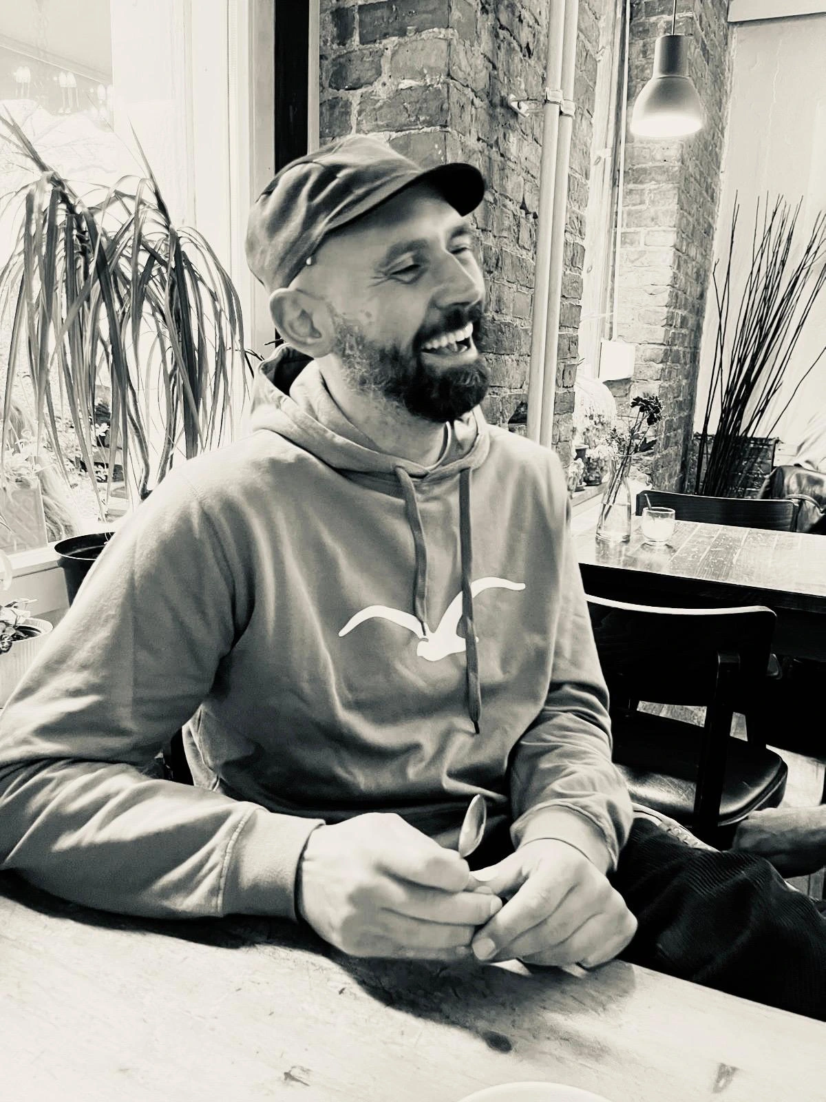 Geschäftsführer Oliver Ambarian Bild am Tisch fröhlich lachend